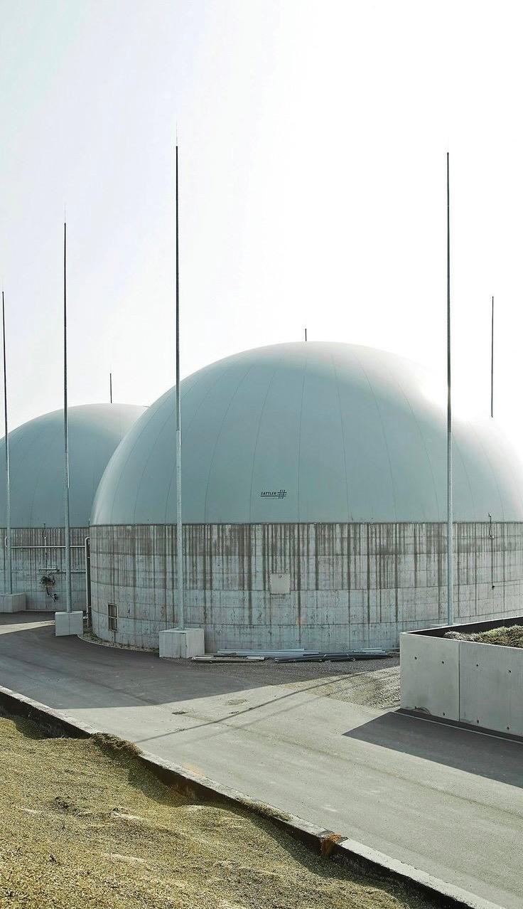 Two domed double-membrane gas holders on round concrete tanks at a biogas plant